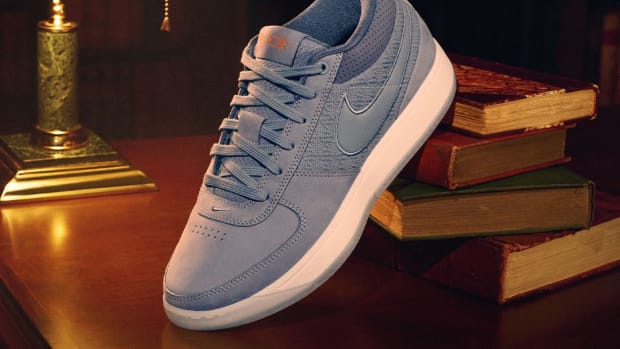Devin Booker's grey Nike sneakers sit on top of books.